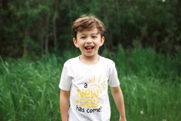 Jakob Guziak smiles in a grassy field.