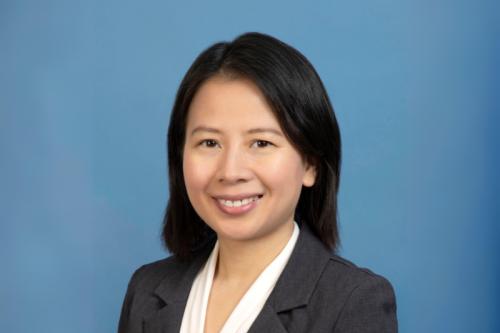 A woman in formal wear smiles into the camera.