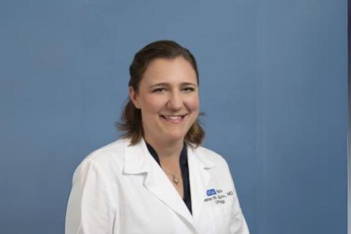 Researcher Renea Sturm smiles in a white coat.