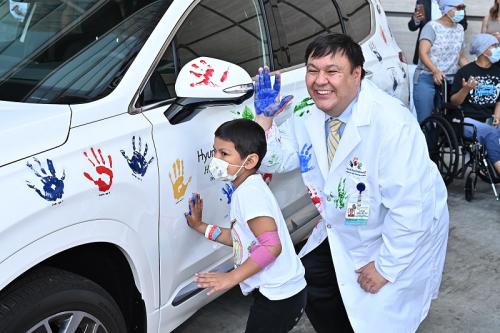 Dr. Steven Jonas and a patient at UCLA Mattel Children's Hospital put their handprints on a Hyundai during a celebration of Dr. Jonas receiving a $400,000 research grant. 