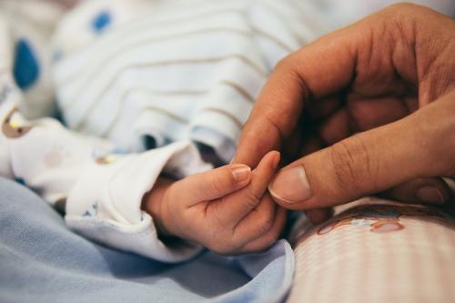 Parent holds tiny hand.