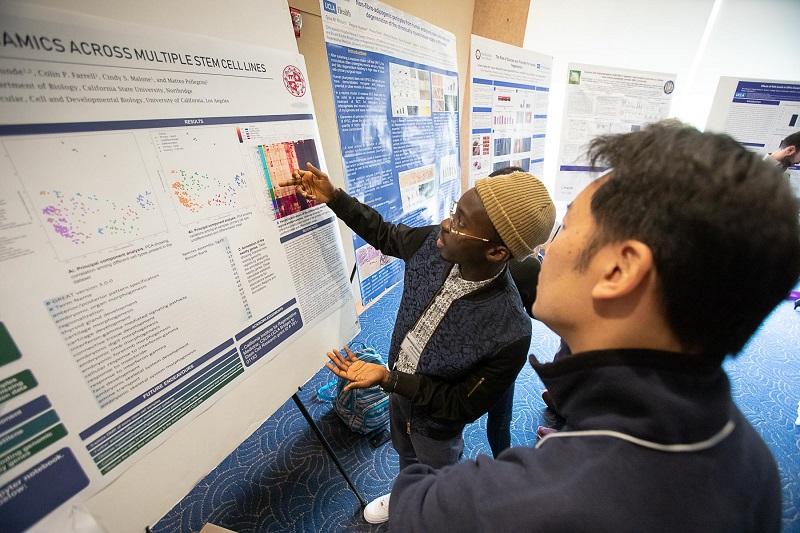 Ahmed Oyetunde (left), a former CSUN-UCLA intern in the lab of Matteo Pellegrini, presents his research project at the UCLA Broad Stem Cell Research Center’s 15th annual Stem Cell Symposium.