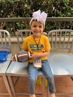 Ava Langenhop holds a UCLA football