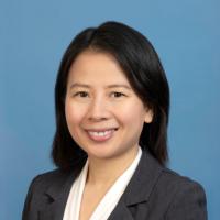 A woman in formal wear smiles into the camera.