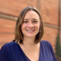 A woman smiles into the camera.