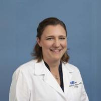 Researcher Renea Sturm smiles in a white coat.